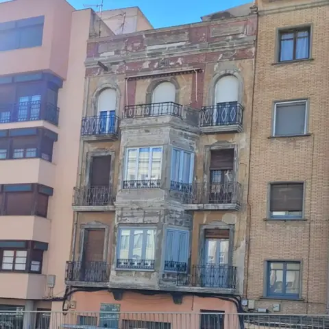 Antes: fachada antigua con balcones de forja y miradores